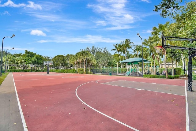 view of basketball court featuring a playground