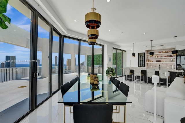 dining room featuring recessed lighting, marble finish floor, a city view, and french doors