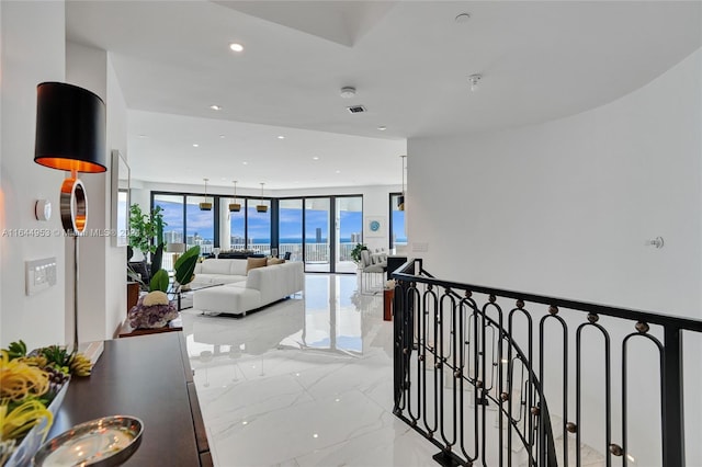 corridor with recessed lighting, marble finish floor, visible vents, and an upstairs landing