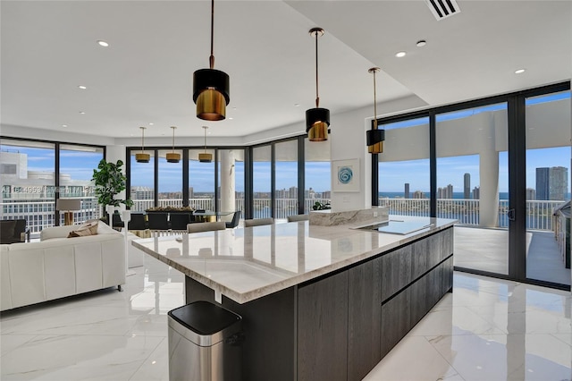 kitchen featuring a spacious island, modern cabinets, open floor plan, hanging light fixtures, and a view of city