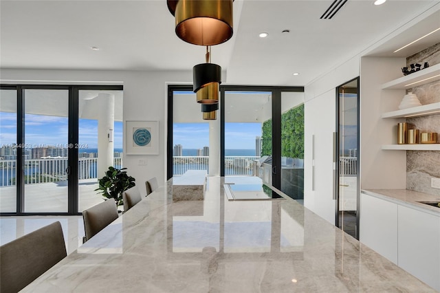 dining area with recessed lighting, a city view, and a water view