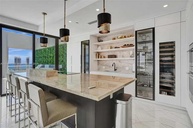 kitchen with light stone counters, marble finish floor, hanging light fixtures, and open shelves