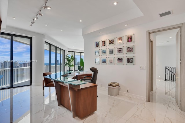 office with rail lighting, a water view, and light tile patterned floors