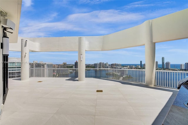 view of patio / terrace featuring a water view and a city view