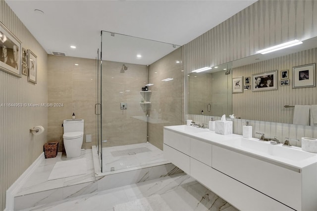 bathroom featuring tile patterned floors, double sink vanity, tile walls, toilet, and a shower with door