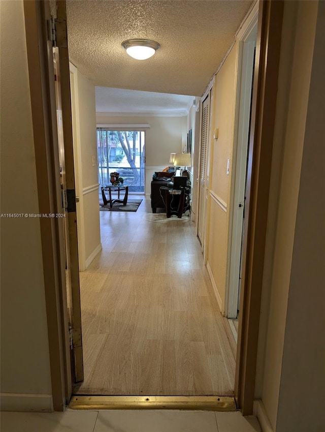 corridor featuring a textured ceiling and light wood-type flooring