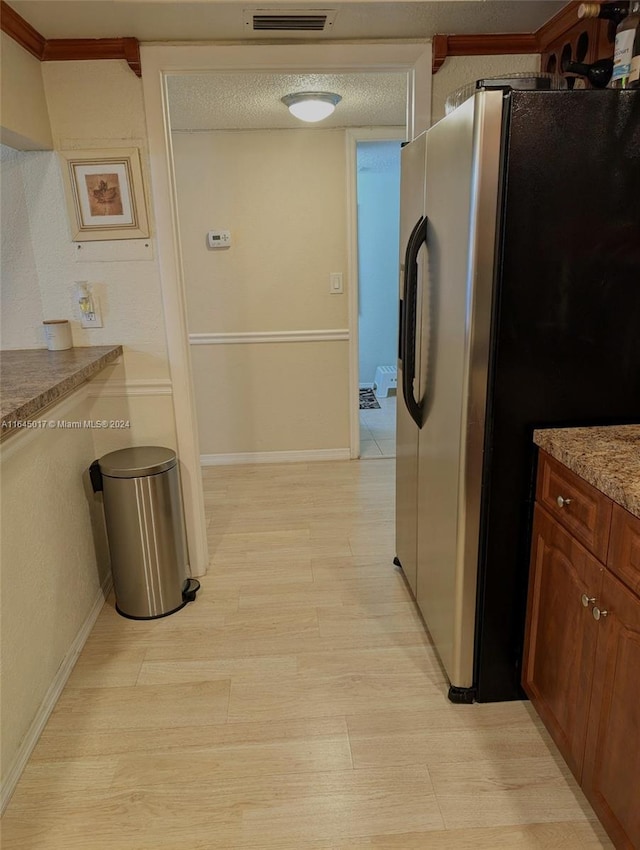 kitchen with visible vents, stainless steel fridge with ice dispenser, brown cabinets, a textured ceiling, and light wood-style floors