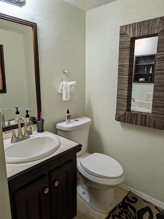 half bathroom with toilet, a textured wall, tile patterned flooring, and vanity