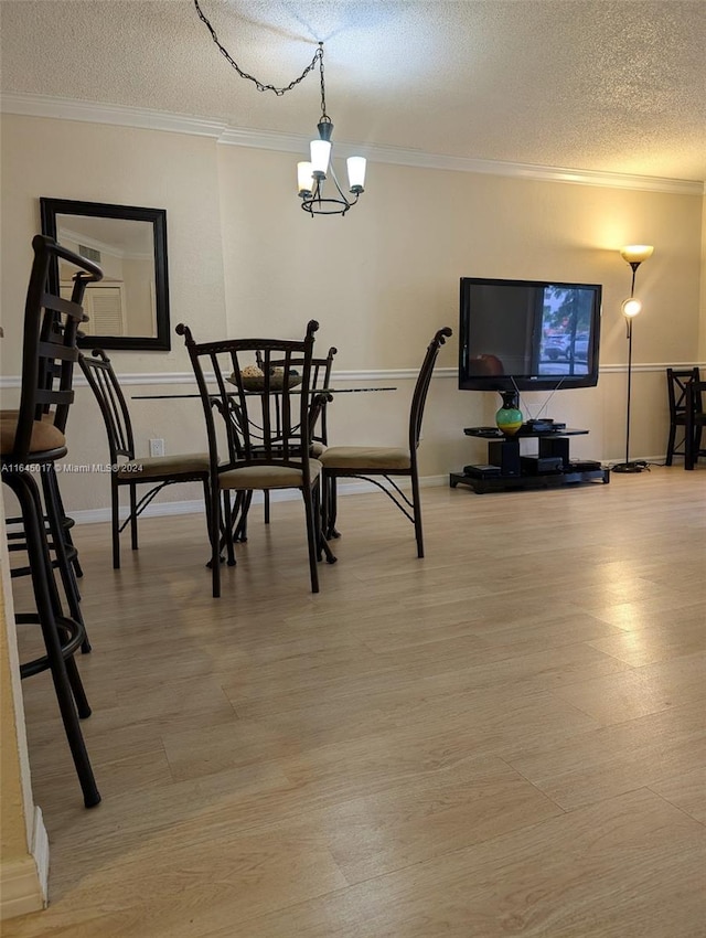 dining area featuring a textured ceiling, an inviting chandelier, wood finished floors, and crown molding