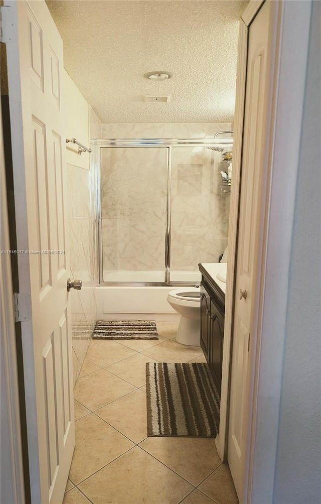 bathroom with tile patterned flooring, enclosed tub / shower combo, and vanity