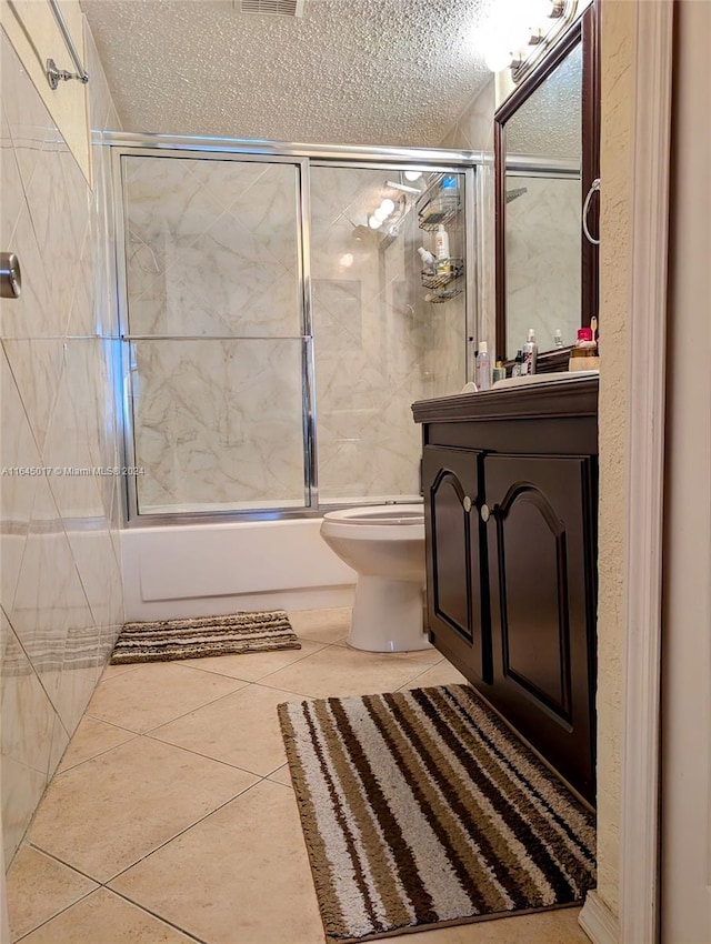 full bath featuring toilet, enclosed tub / shower combo, vanity, a textured ceiling, and tile patterned floors