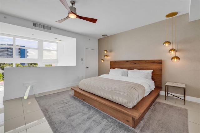 tiled bedroom featuring ceiling fan