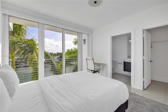 tiled bedroom with connected bathroom, access to outside, and a water view