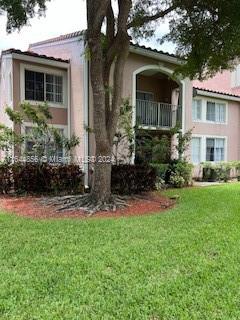 view of side of home featuring a balcony and a lawn