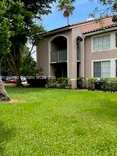 view of front of house featuring a front lawn and a balcony