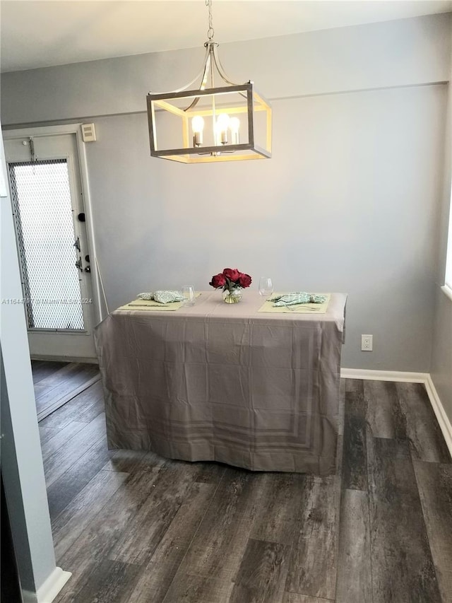 dining room with dark hardwood / wood-style flooring and a chandelier