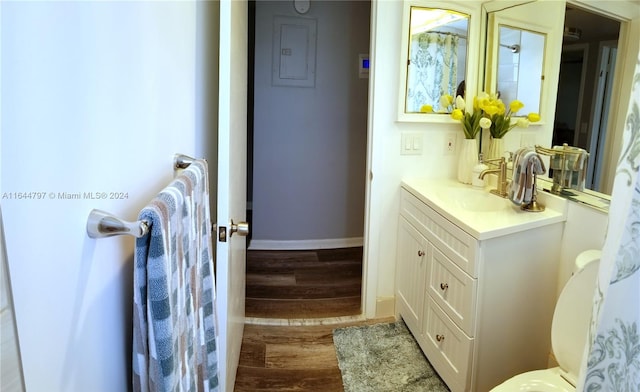 bathroom featuring hardwood / wood-style flooring, toilet, and vanity