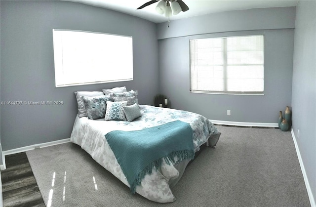 bedroom with multiple windows, baseboards, dark carpet, and a ceiling fan