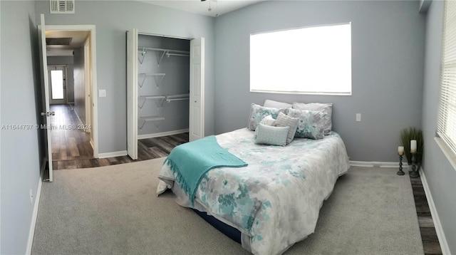 bedroom featuring hardwood / wood-style floors, a closet, and multiple windows