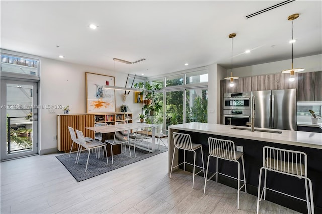 dining space featuring light hardwood / wood-style floors and a wall of windows