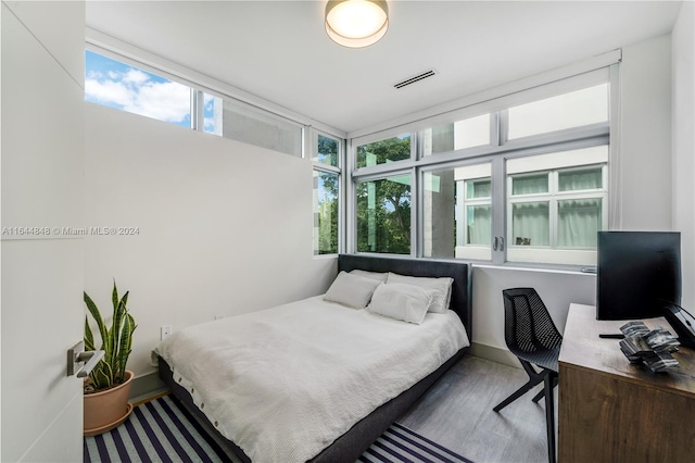 bedroom featuring multiple windows and hardwood / wood-style flooring