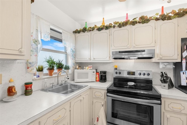 kitchen with stainless steel range with electric stovetop, decorative backsplash, and sink