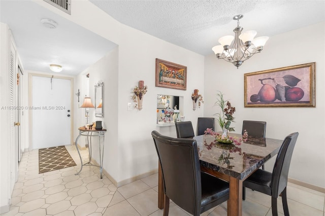 dining room featuring a chandelier and a textured ceiling