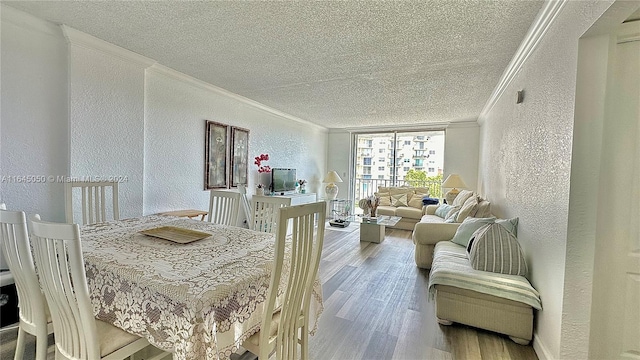 dining space featuring a textured ceiling, ornamental molding, and hardwood / wood-style floors