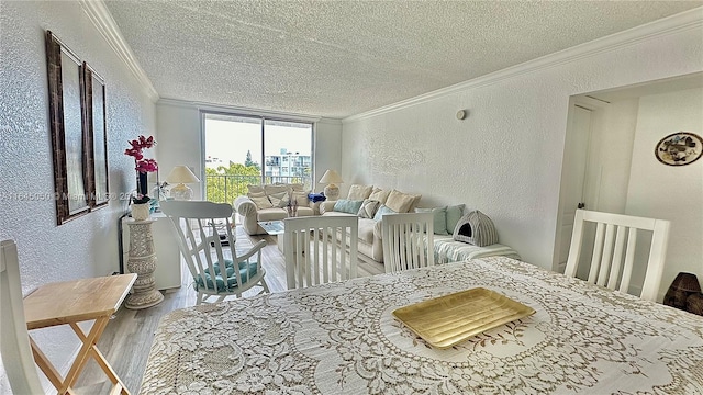 dining room featuring ornamental molding, a textured ceiling, and hardwood / wood-style floors