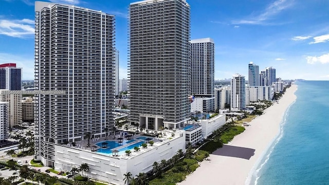 property's view of city featuring a water view and a beach view