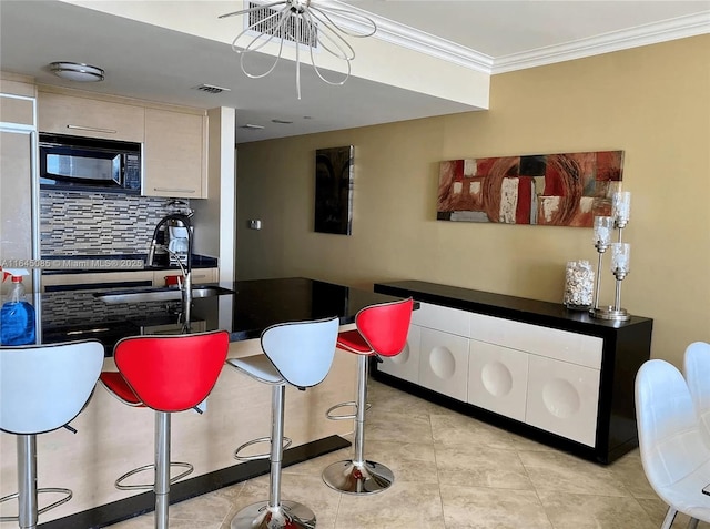 1850 S Ocean Dr Unit 3809, Hallandale Beach, FL 33009 - kitchen with black microwave, tasteful backsplash, ornamental molding, a kitchen breakfast bar, and dark countertops