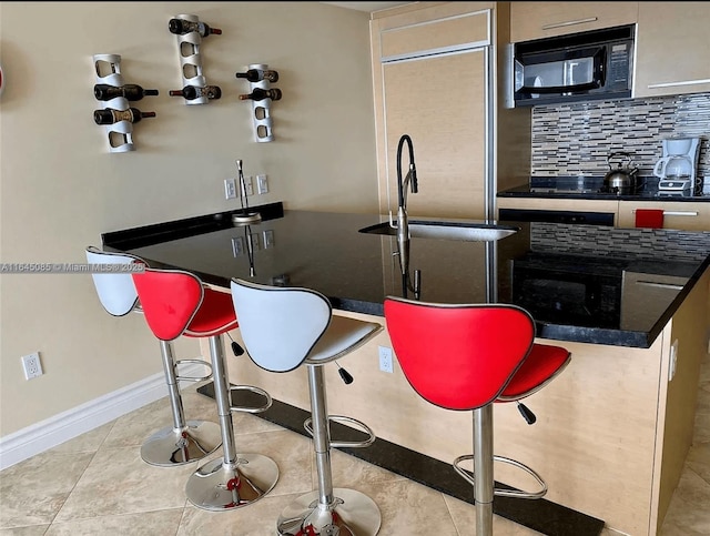 1850 S Ocean Dr Unit 3809, Hallandale Beach, FL 33009 - kitchen with black microwave, tasteful backsplash, light tile patterned floors, and paneled refrigerator