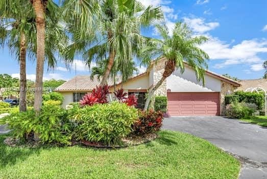 view of front of home with a garage and a front lawn