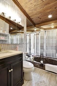 bathroom with wood ceiling, vanity, and toilet