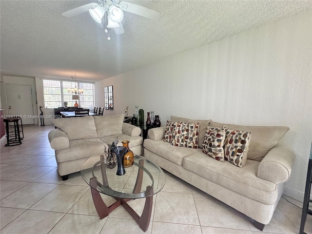 living room with a textured ceiling, ceiling fan with notable chandelier, and light tile patterned floors