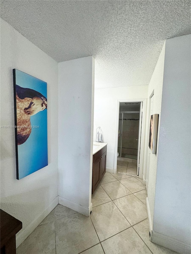 interior space featuring a textured ceiling, vanity, and tile patterned floors