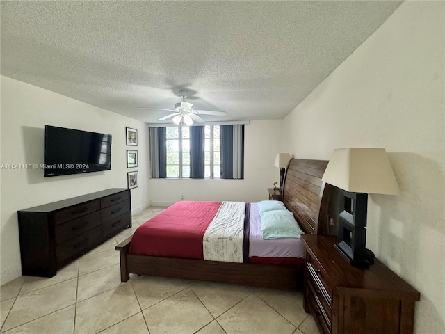 tiled bedroom with ceiling fan and a textured ceiling