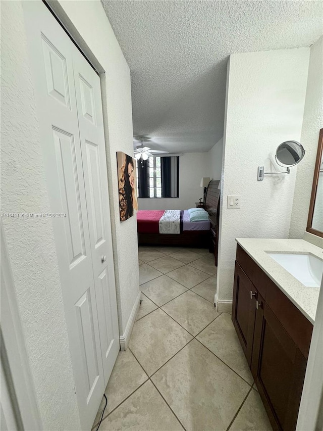 bathroom featuring a textured ceiling, ceiling fan, vanity, and tile patterned floors