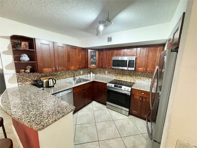 kitchen featuring appliances with stainless steel finishes, sink, kitchen peninsula, and decorative backsplash