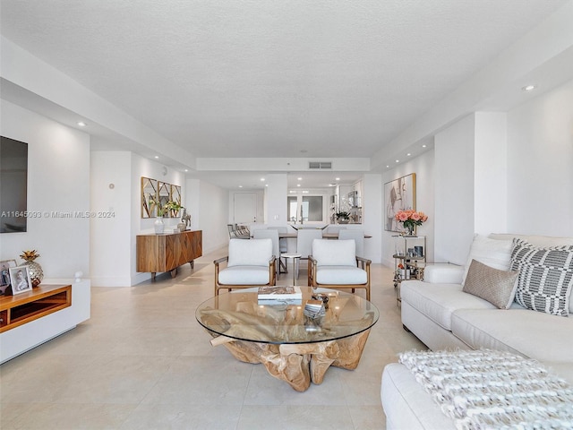 tiled living room featuring a textured ceiling