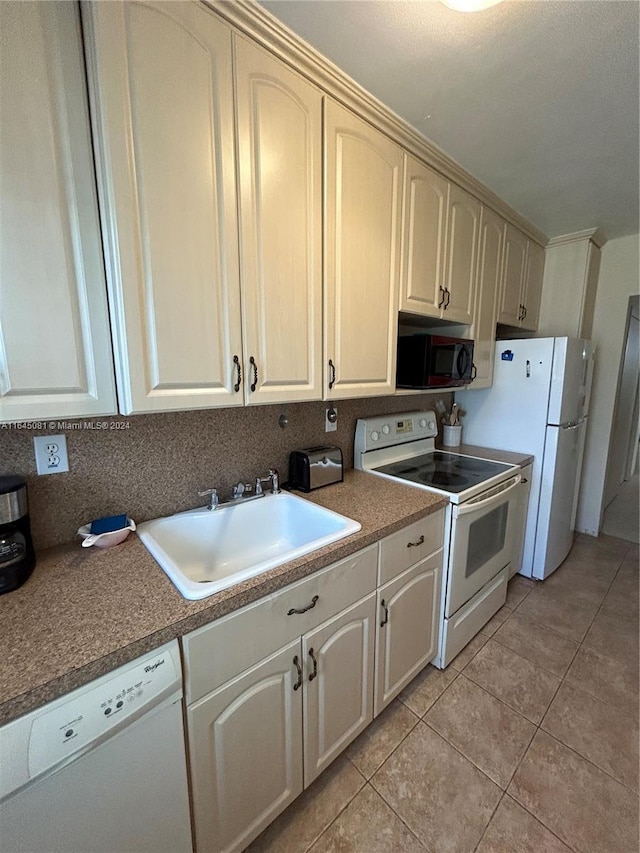 kitchen with sink, light tile patterned floors, and white appliances