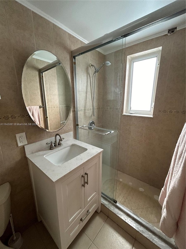 bathroom with vanity, a shower with door, toilet, ornamental molding, and tile walls