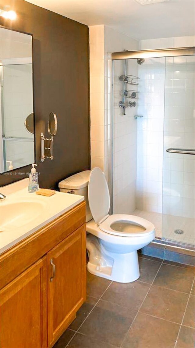 full bathroom with vanity, a shower stall, toilet, and tile patterned floors