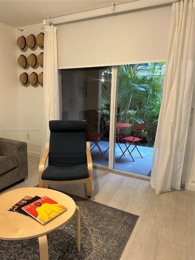 living area with light wood-type flooring and a textured ceiling