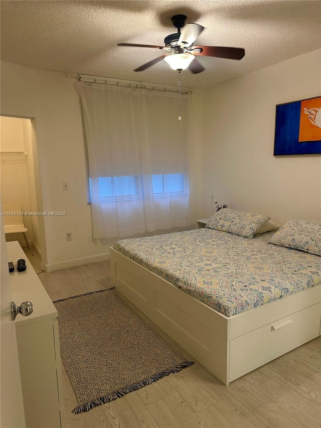 bedroom featuring a textured ceiling, light hardwood / wood-style flooring, and ceiling fan