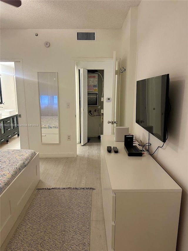 bathroom with wood-type flooring, ceiling fan, vanity, and a textured ceiling