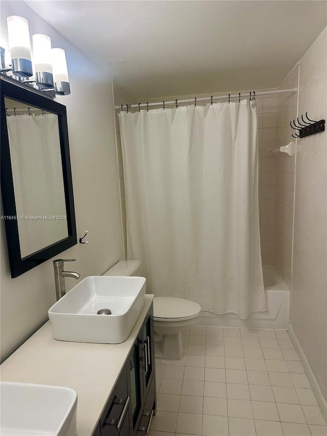 full bathroom featuring tile patterned floors, shower / bath combination with curtain, toilet, and vanity