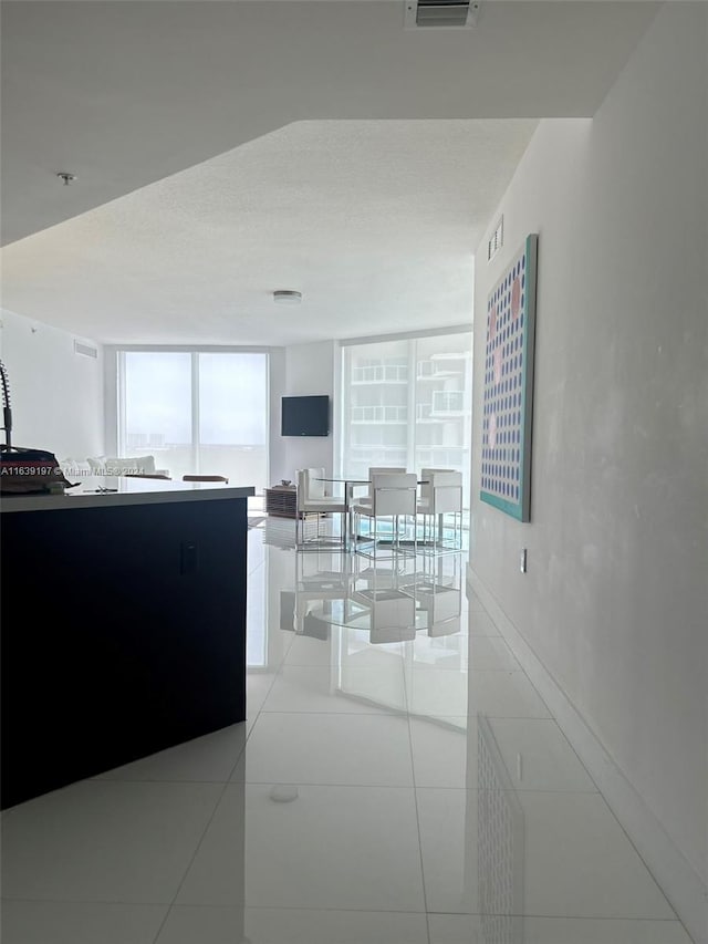 kitchen with floor to ceiling windows and light tile patterned floors