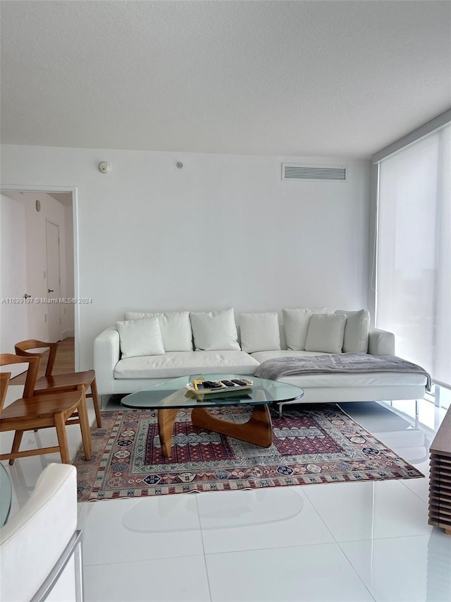 living room with a textured ceiling and tile patterned floors