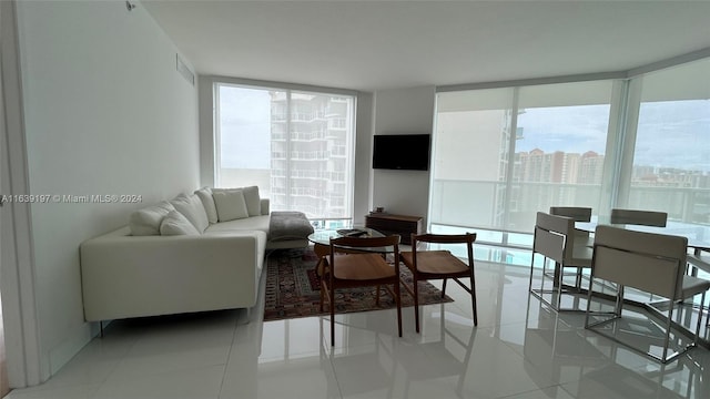 tiled living room featuring plenty of natural light and floor to ceiling windows